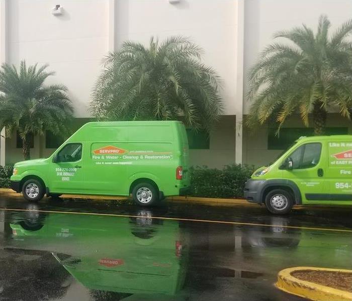 SERVPRO vans in front of a cream stucco building