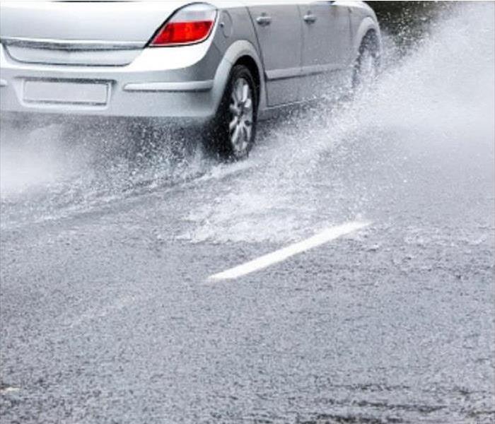 Car driving thorough Water in the Road